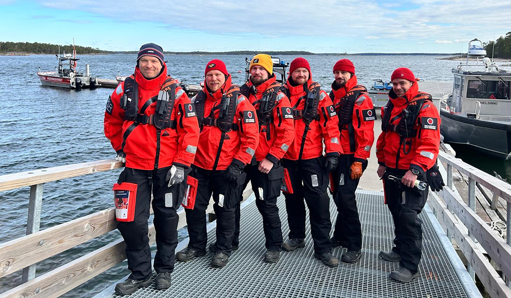 Kuusi kouluttajaa veneen kannella.